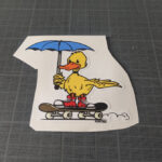 Un canard sur 4 roues sous un parapluie